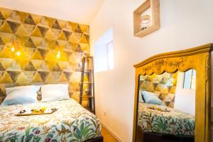 - une chambre avec un lit doté d'une tête de lit dorée dans l'établissement Sauna - Le loft des remparts - FloBNB, à Laon