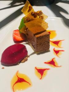 um pedaço de bolo de chocolate e uma fruta num prato em Skaslien Hotel & Guesthouse em Kirkenær