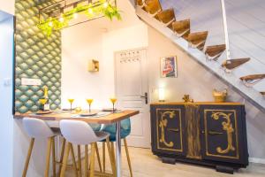 une salle à manger avec une table, des chaises et un escalier dans l'établissement Sauna - Le loft des remparts - FloBNB, à Laon