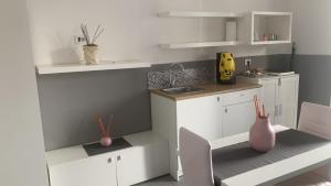 a kitchen with white cabinets and a pink vase at Sky house Napoli in Naples