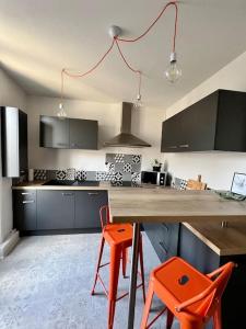 een keuken met een houten aanrecht en 2 oranje stoelen bij Casa Gambetta #15 - Sublime T2 Moderne & Design - Brive Coeur de Ville in Brive-la-Gaillarde