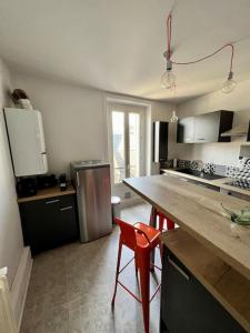 een keuken met een aanrecht en rode stoelen. bij Casa Gambetta #15 - Sublime T2 Moderne & Design - Brive Coeur de Ville in Brive-la-Gaillarde
