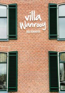 ein Backsteingebäude mit einem Schild an der Seite in der Unterkunft Villa Wanrooy in Doetinchem