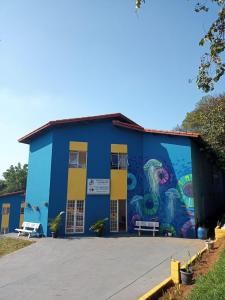 un bâtiment bleu avec une peinture sur son côté dans l'établissement Pousada Clube Universo Esportivo, à São Paulo