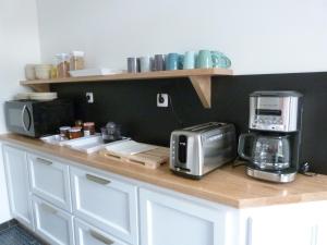 a kitchen with a counter with a toaster and a microwave at Aux Portes des Lacs in Ardres