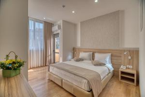 a bedroom with a large bed and a large window at Orbeli Hotel Yerevan in Yerevan