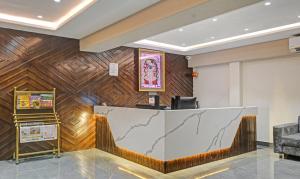 a lobby with a reception desk and wooden wall at Treebo Trend Z in Bhilwara