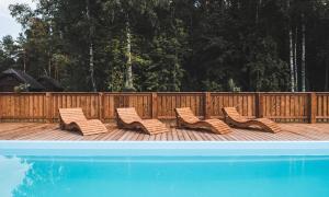 a group of chairs sitting on a deck next to a pool at Metsaluige Turismitalu in Kabli