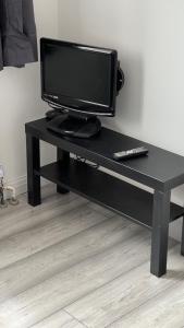 a black desk with a television and a remote control at Aaby House in London in Croydon