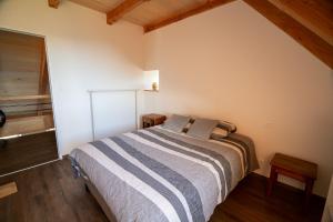 um quarto com uma cama num quarto com pisos em madeira em Appartement de 2 chambres avec balcon amenage a Saint Come d'Oltc em Saint-Côme-dʼOlt