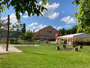 un parque con parque infantil y una tienda en el césped en Jazdecký areál Budička, 