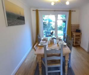 ein Esszimmer mit einem Tisch, Stühlen und einem Fenster in der Unterkunft Peaceful 4 bedroom house with free parking in Frimley