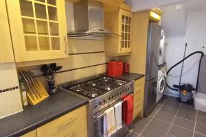 a kitchen with a stove and a refrigerator at Peaceful 4 bedroom house with free parking in Frimley