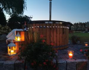 a hot tub with candles and lights in a yard at Wierzbowy Zakątek Lubocino - apartament na wyłączność, sauna, balia, ognisko in Lubocino