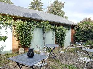 una mesa y sillas frente a un edificio en Studio LE VINTAGE - Maison 1911 - confort & prestige, en Gien