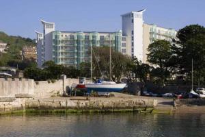 a boat parked on the shore of a body of water at Quayside Apartment - Large and Spacious Duplex in Castletown
