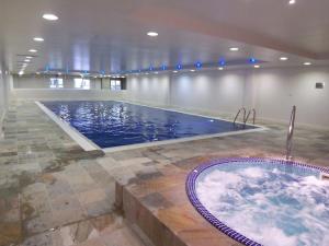 een groot zwembad met een bad in een kamer bij Quayside Apartment - Large and Spacious Duplex in Castletown