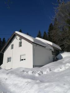 a white house with snow on top of it at Ferienhaus Plöckenstein in Schwarzenberg am Bohmerwald