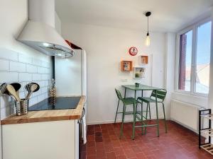 a kitchen with a counter and a table and chairs at Studio LE VINTAGE - Maison 1911 - confort & prestige in Gien +7 photos
