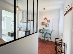 Habitación con espejo y cocina con mesa. en Studio LE VINTAGE - Maison 1911 - confort & prestige, en Gien