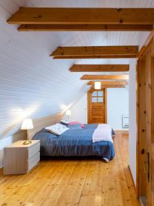1 dormitorio con 1 cama y suelo de madera en Weissenbacherhof B&B en Oslip