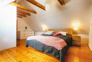 1 dormitorio con 1 cama y pared de madera en Weissenbacherhof B&B en Oslip