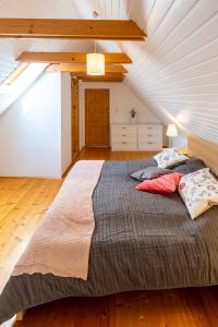 ein Schlafzimmer mit einem großen Bett im Dachgeschoss in der Unterkunft Weissenbacherhof B&B in Oslip