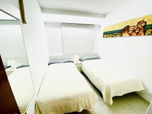 1 Schlafzimmer mit 2 Betten und einem Spiegel in der Unterkunft RHASIMAR SALOU CENTRO in Salou