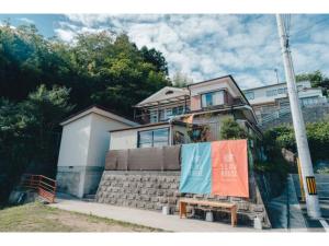 una casa con un cartel delante de ella en SLOW HOUSE kesennuma - Vacation STAY 30922v en Kesennuma