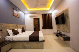 a bedroom with a bed and a flat screen tv at Hotel Keptown in Jaipur