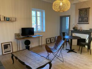 un soggiorno con TV, tavolo e sedie di 16 Bis-Gîte-Hôtel-Appartement a Marssac-sur-Tarn