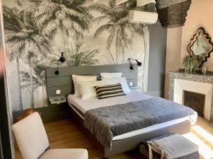 a bedroom with a bed with a mural of palm trees at 16 Bis-Gîte-Hôtel-Appartement in Marssac-sur-Tarn
