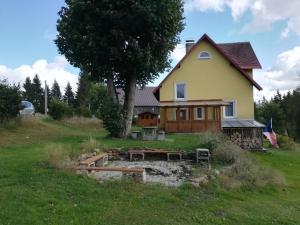 a house with a pond in front of it at Chata Rybná 18 in Pernink