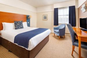 a hotel room with a bed and a desk and a computer at Mercure Bolton Georgian House Hotel in Bolton