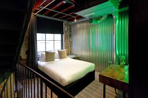 a bedroom with a bed in a room with green lights at Blayds Yard in Leeds