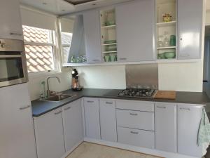 - une cuisine blanche avec des placards blancs et un évier dans l'établissement Appartement B&B Pandhouse, à Oud-Beijerland