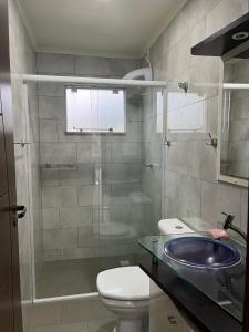 a bathroom with a shower and a toilet and a sink at La Lola Residencial in Bombinhas