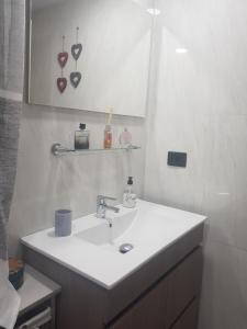 a white bathroom with a sink and a mirror at CABO PARAISO in Costa de Antigua