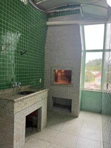 Baño de azulejos verdes con chimenea y fregadero en La Lola Residencial, en Bombinhas 61 fotos más