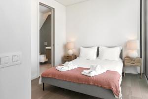 a bedroom with a bed with two white towels on it at Prata Riverside Apartment in Lisbon