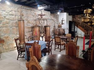 jadalnia ze stołami i krzesłami oraz kamienną ścianą w obiekcie Casario do Vale Hospedagem e Eventos 
