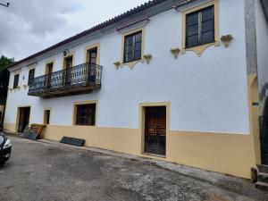 a white building with windows and a balcony at Casario do Vale Hospedagem e Eventos in Assento