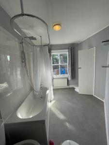 une salle de bain avec une baignoire, un lavabo et une fenêtre dans l'établissement Brady’s Glastonbury beautiful pad great location!, à Glastonbury