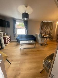 ein Wohnzimmer mit einem blauen Sofa und einem Tisch in der Unterkunft Brady’s Glastonbury beautiful pad great location! in Glastonbury