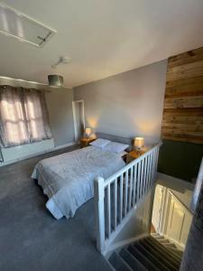 ein Schlafzimmer mit einem Bett, zwei Lampen und einer Treppe in der Unterkunft Brady’s Glastonbury beautiful pad great location! in Glastonbury
