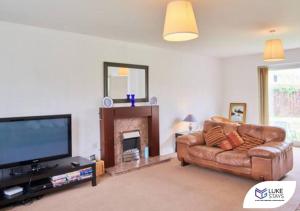 a living room with a couch and a flat screen tv at Luke Stays - The Green in West Cornforth