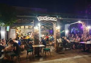 a group of people sitting at tables in a restaurant at Apartmani Plazibat in Mandre
