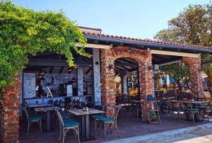 un patio al aire libre con mesas y sillas y un edificio de ladrillo en Apartmani Plazibat, en Mandre