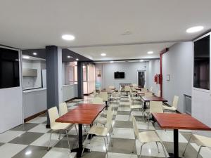 Hotel AATRAC Buenos Aires في بوينس آيرس: وجود كافتيريا بالطاولات والكراسي في مبنى