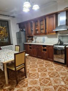 cocina con armarios de madera, mesa y fogones en Benevo Hostel en Tiflis